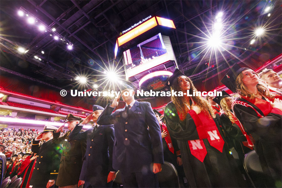 Students including the ROTC graduating cadets salute the flag during the National Anthem. Winter undergraduate commencement in Pinnacle Bank Arena. December 16, 2023. Photo by Craig Chandler / University Communication and Marketing.