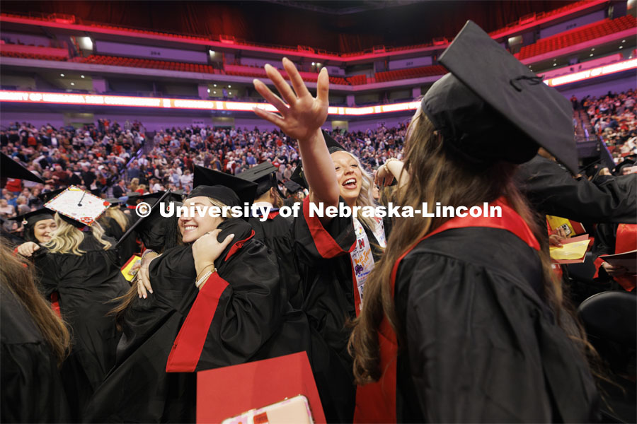 Anna Dukart, left, and Paxtyn Dummer hug friends at the end of Regent Tim Clare’s greeting where the regent asked graduates to show their appreciation for their friends and fellow graduates. Winter undergraduate commencement in Pinnacle Bank Arena. December 16, 2023. Photo by Craig Chandler / University Communication and Marketing.