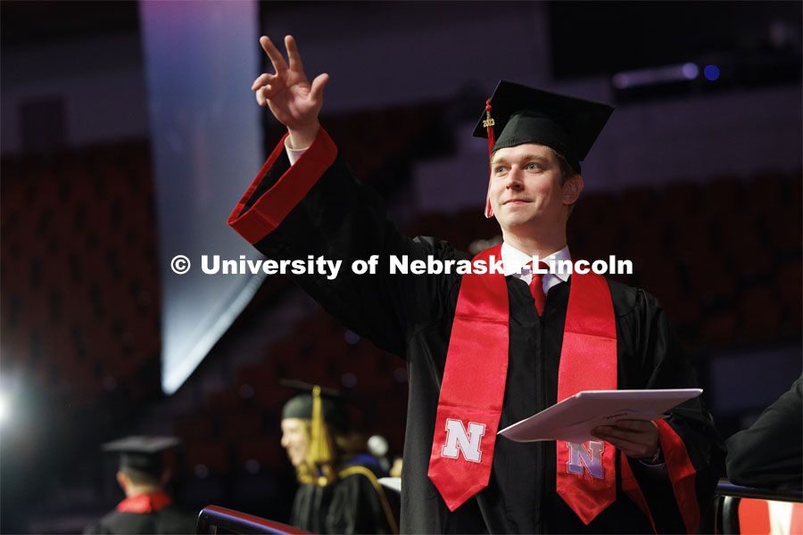 Connor Loftus waves to family and friends after receiving his business diploma. Winter undergraduate commencement in Pinnacle Bank Arena. December 16, 2023. Photo by Craig Chandler / University Communication and Marketing.