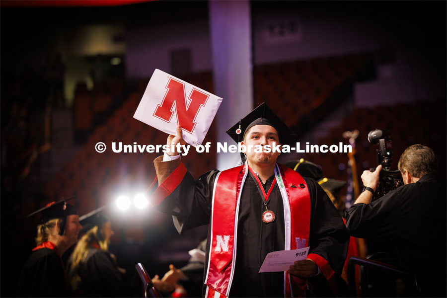 Antonio de Jesus Soto shows off his College of Arts and Sciences diploma to family and friends. Winter undergraduate commencement in Pinnacle Bank Arena. December 16, 2023. Photo by Craig Chandler / University Communication and Marketing.