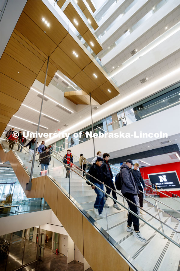 A long straight staircase separates the first and second floor before the stairs wind up the east side of the atrium. First day of classes in Kiewit Hall. January 22, 2024. Photo by Craig Chandler / University Communication and Marketing.