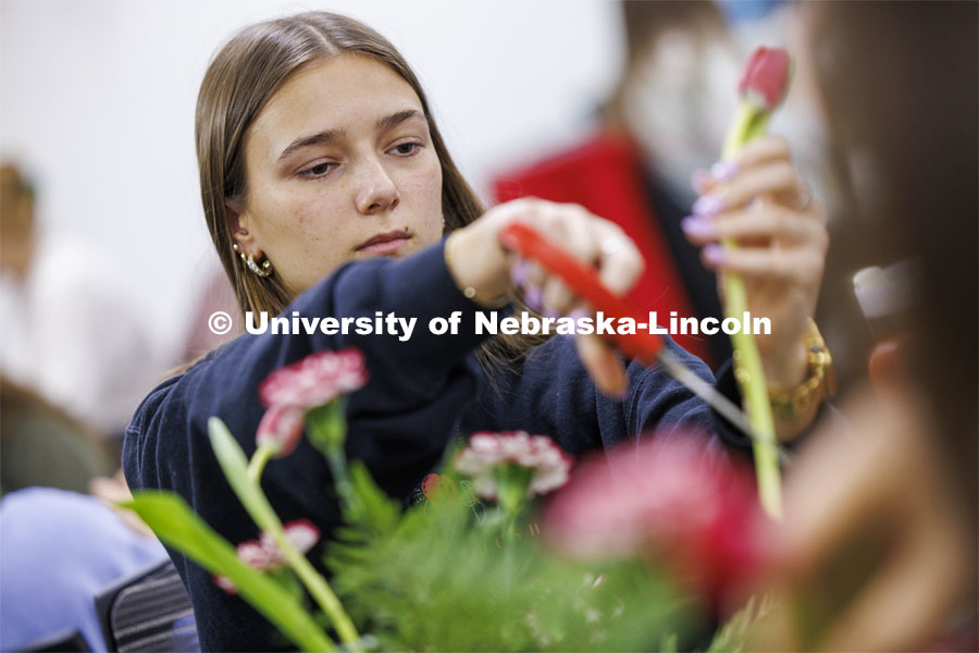 Anna Pinkall cuts the stem of a tulip. Stacy Adams teaches PLAS 261 - Floral Design I in the Plant Science Building on East Campus. February 14, 2024. Photo by Craig Chandler / University Communication and Marketing.