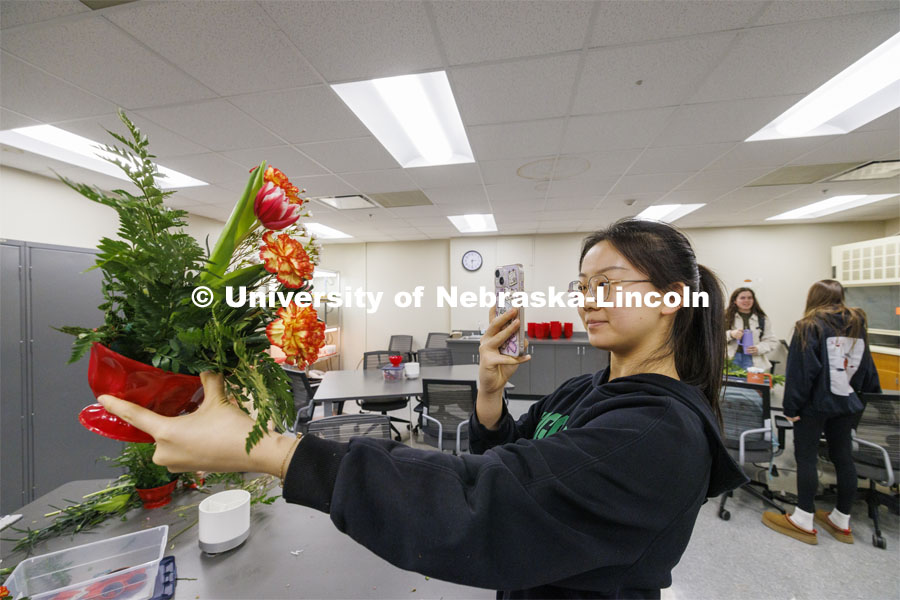 Yuchu Jiang takes a photo of her bouquet. Stacy Adams teaches PLAS 261 - Floral Design I in the Plant Science Building on East Campus. February 14, 2024. Photo by Craig Chandler / University Communication and Marketing.