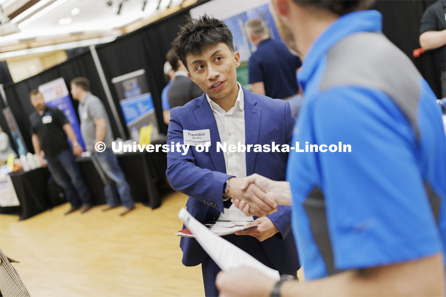 Francisco Becerra, a junior in construction management, talks with a representative from ISEC. University Career + Internship Fair in the Nebraska Union. February 15, 2024. Photo by Craig Chandler / University Communication and Marketing.