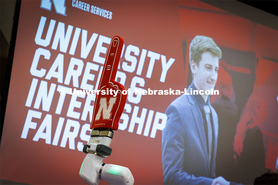 A foam finger on a robotic arm at the Rensenhouse manufacturing booth waves to Huskers. University Career + Internship Fair in the Nebraska Union. February 15, 2024. Photo by Craig Chandler / University Communication and Marketing.