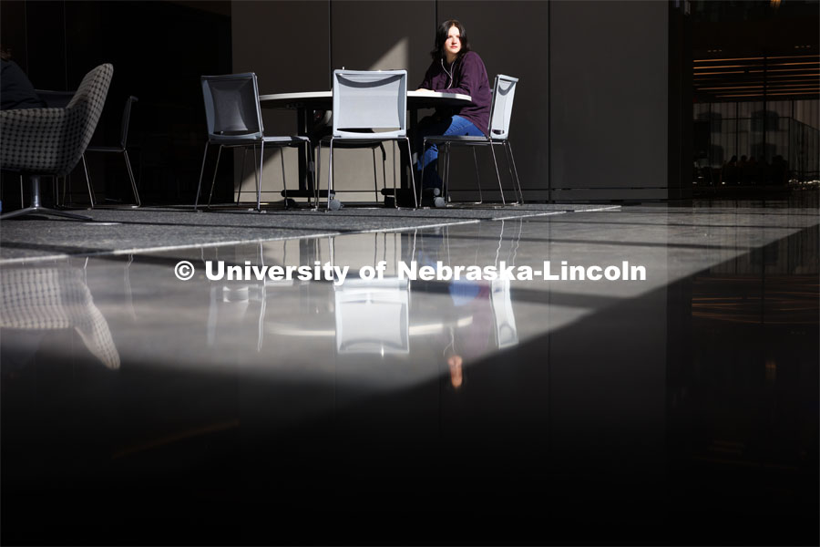 Madison West, a junior in accounting, found a sunny spot to study in Kiewit Hall.  February 23, 2024. Photo by Craig Chandler / University Communication and Marketing.