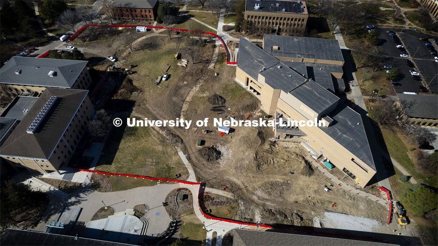 A red fence surrounds the construction area on East Campus Legacy Plaza in the greenspace. Aerial view of East Campus construction. February 26, 2024. Photo by Craig Chandler / University Communication and Marketing.