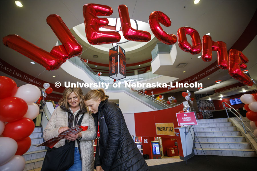 Misty and Kaegan Fredrickson of Britton, South Dakota, look over the program under a welcoming balloon arch in the Nebraska Union. Admitted Student Day is UNL’s in-person, on-campus event for all admitted students. March 23, 2024. Photo by Craig Chandler / University Communication and Marketing.