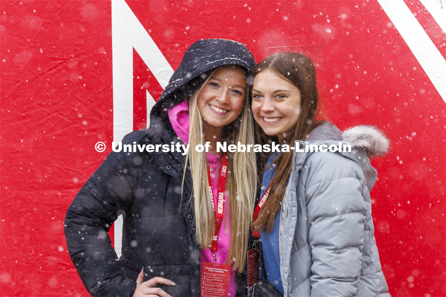Ava Schmaderer and Makenna Lichty, both of Bennington, Nebraska, try to catch snowflakes on their tongues while being photographed in front of the inflatable N outside the Nebraska Union. Admitted Student Day is UNL’s in-person, on-campus event for all admitted students. March 23, 2024. Photo by Craig Chandler / University Communication and Marketing.