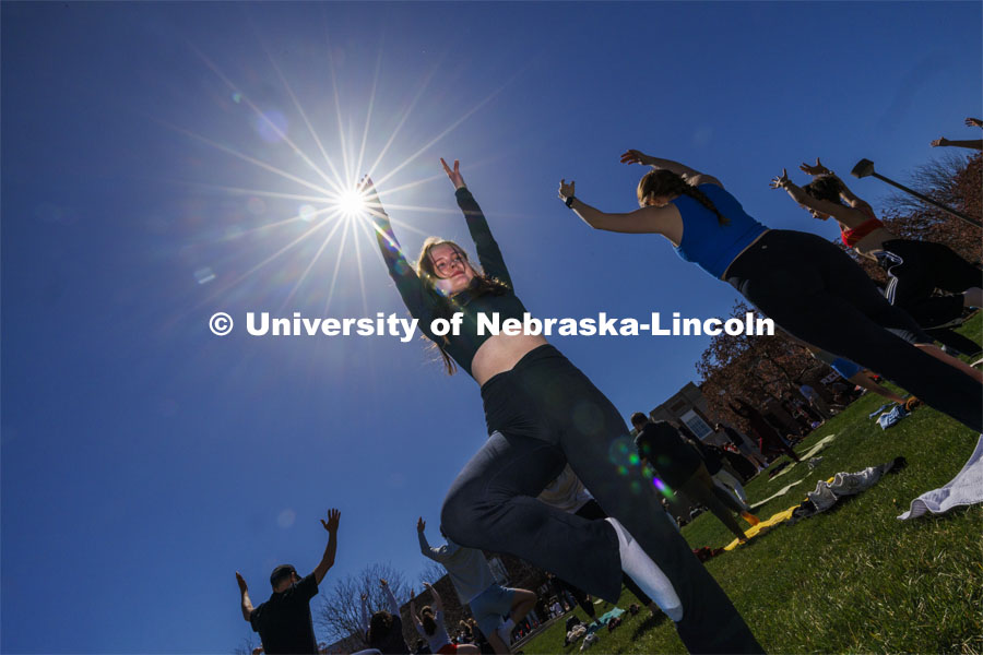 TJ Cass holds the tree pose during yoga on the greenspace during the eclipse. The Solar Social party to view the partial solar eclipse filled the greenspace outside the Nebraska Union on City Campus. April 8, 2024. Photo by Craig Chandler / University Communication and Marketing.