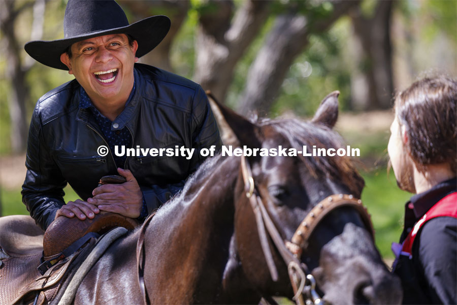 Hector Palala dismounts after receiving a ride on one of the rodeo horses. He borrowed the hat so he’d look the part as he rode. The Nebraska Rodeo Team gave Huskers a chance to be up close to their horses and even go for a ride. The team filled the space northwest of the Union to help promote their Nebraska Cornhusker College Rodeo being held Friday and Saturday. April 29, 2024. Photo by Craig Chandler / University Communication and Marketing.