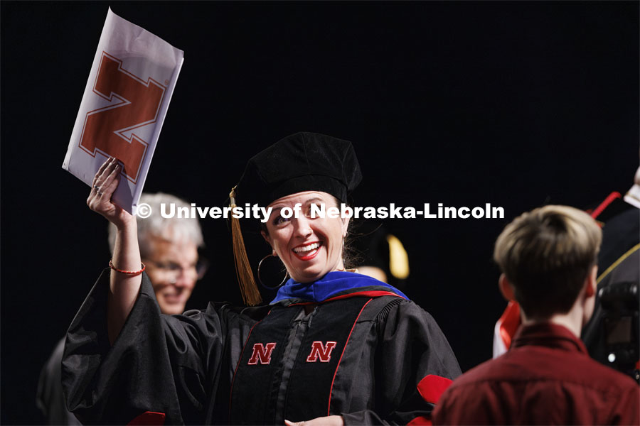 Doctoral candidate Renca Dunn holds up her diploma after her doctoral hooding. Graduate Commencement. May 17, 2024. Photo by Craig Chandler / University Communication and Marketing.