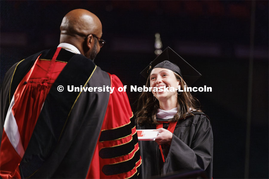 Graduate receives her diploma from Chancellor Bennett at Graduate Commencement. May 17, 2024. Photo by Craig Chandler / University Communication and Marketing.