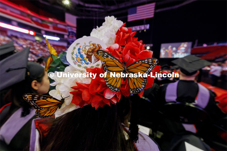 Angela Quezada attached artificial Monarch butterflies and colored tissue paper to represent her country’s flag to her mortarboard. Graduate Commencement. May 17, 2024. Photo by Craig Chandler / University Communication and Marketing.