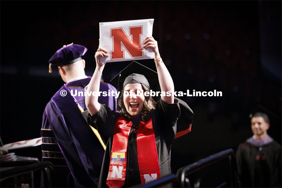 Karolayn Greys Chavez Loor celebrates and shows her Masters of Architecture diploma to family and friends. Graduate Commencement. May 17, 2024. Photo by Craig Chandler / University Communication and Marketing.