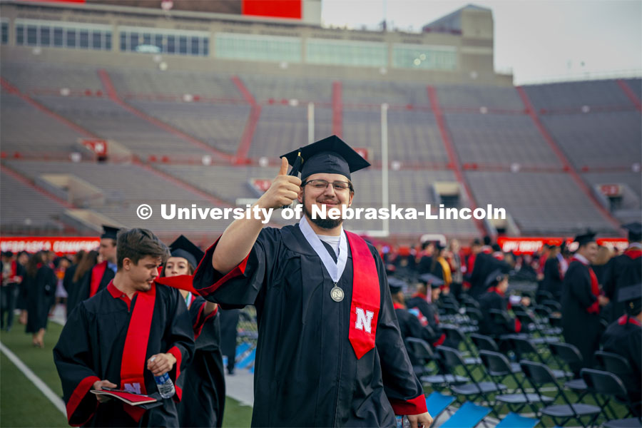Andrew Voggesser, a Music major, gives a thumbs up to a friend in the crowd. Undergraduate Commencement in Memorial Stadium. May 18, 2024. Photo by Kristen Labadie / University Communication.
