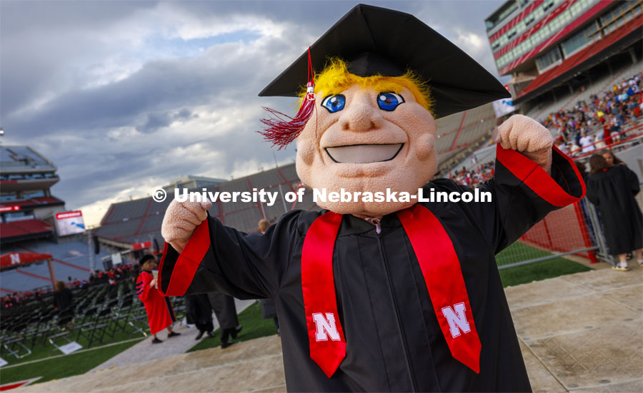 Herbie Husker in his graduation regalia flexes at undergraduate commencement in Memorial Stadium. May 18, 2024. Photo by Craig Chandler / University Communication and Marketing.