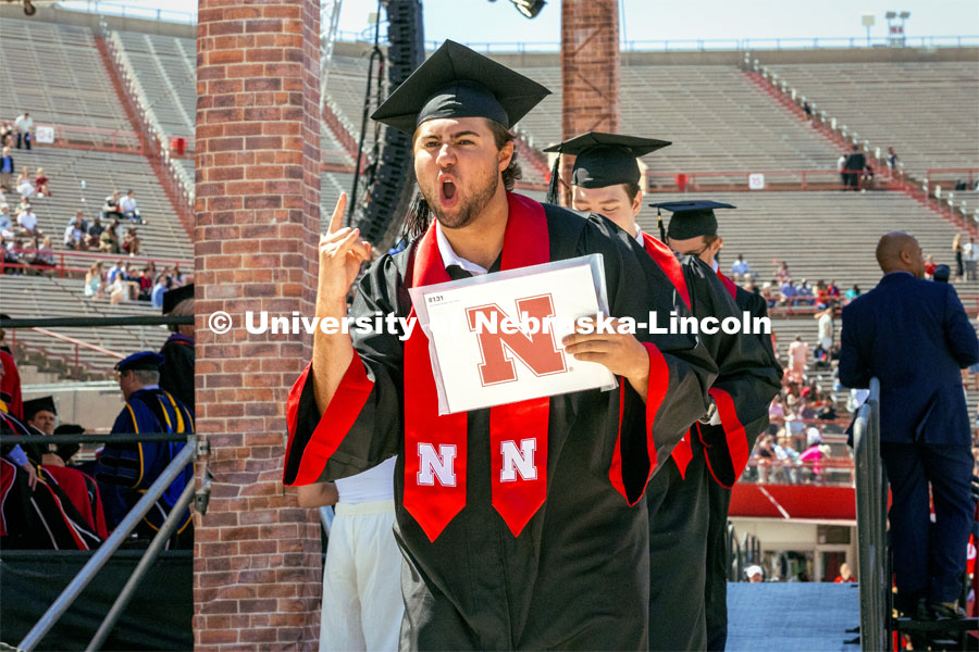 John Mausbach, a College of Engineering Construction Major, celebrates receiving his diploma. Undergraduate Commencement in Memorial Stadium. May 18, 2024. Photo by Kristen Labadie / University Communication.