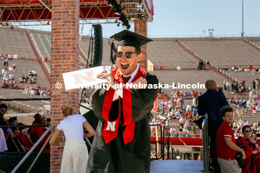 Maxwyll McConnell, a Biological Systems Engineering major, celebrates receiving his diploma by throwing the bones. Undergraduate Commencement in Memorial Stadium. May 18, 2024. Photo by Kristen Labadie / University Communication.