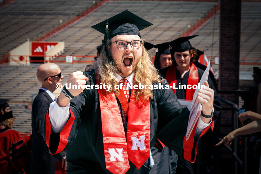 Alex Neill, a Broadcasting and Sports Media and Communications double major, celebrates by whooping as he receives his diploma. Undergraduate Commencement in Memorial Stadium. May 18, 2024. Photo by Kristen Labadie / University Communication.