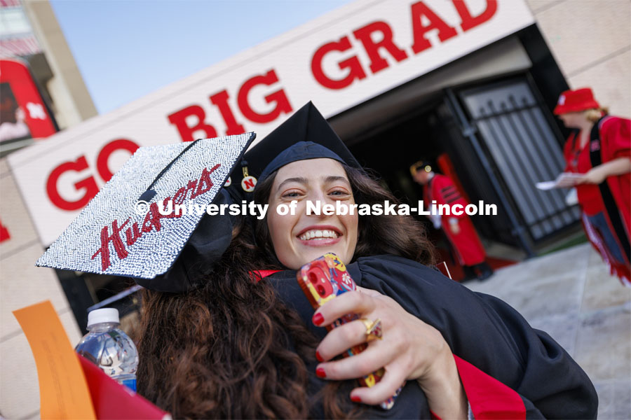 Taylor Strauser is hugged by Haley Hain as they enter the field for commencement. Undergraduate Commencement in Memorial Stadium. May 18, 2024. Photo by Craig Chandler / University Communication and Marketing.