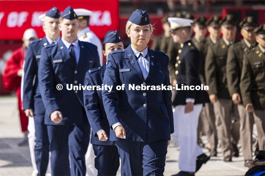 Nineteen ROTC cadets including Air Force Second Lieutenant Taylor Ziepke of Omaha approach the stage to recite their commissioning oath in front of the commencement stage. The actual military and naval commissions have been done over the past couple of days, but the group repeated their oath for the ceremony. Undergraduate Commencement in Memorial Stadium. May 18, 2024. Photo by Craig Chandler / University Communication and Marketing.