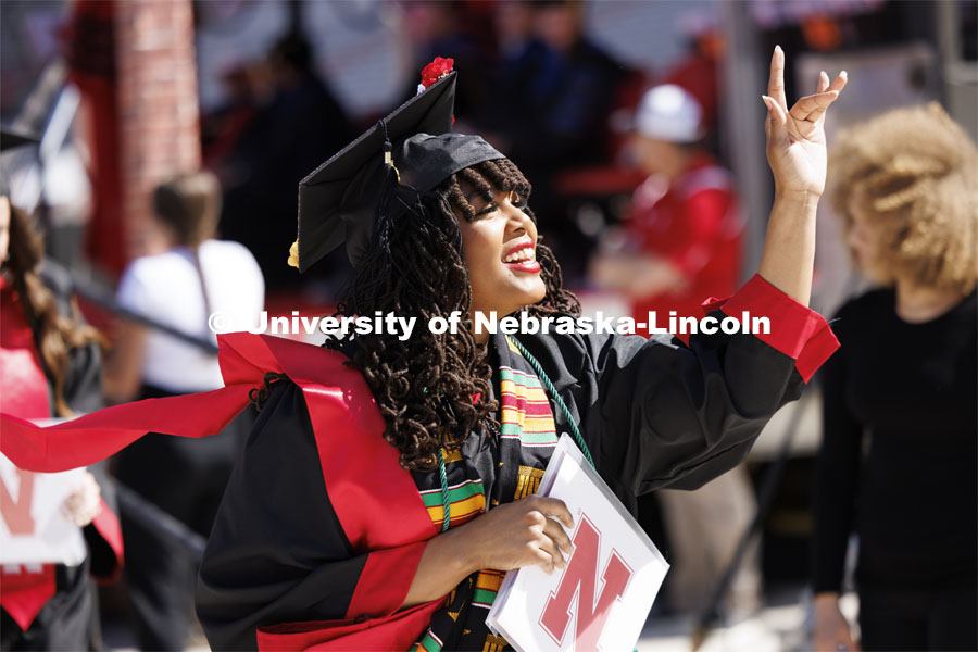 Divyn Williams waves to family and friends after receiving her degree from the College of Business. Undergraduate Commencement in Memorial Stadium. May 18, 2024. Photo by Craig Chandler / University Communication and Marketing.