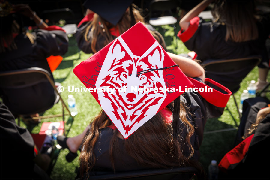 One graduate decorated their mortar board with a red and white design of a wolf. Undergraduate Commencement in Memorial Stadium. May 18, 2024. Photo by Craig Chandler / University Communication and Marketing.
