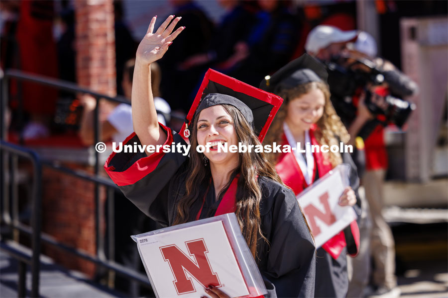 Breanna Glover waves to family and friends after receiving her diploma. Undergraduate Commencement in Memorial Stadium. May 18, 2024. Photo by Craig Chandler / University Communication and Marketing.