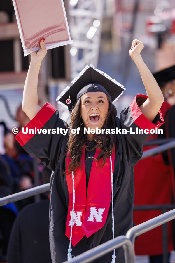Kelsie Bliss celebrates as she sees herself on the HuskerVision screen after receiving her degree. Undergraduate Commencement in Memorial Stadium. May 18, 2024. Photo by Craig Chandler / University Communication and Marketing.