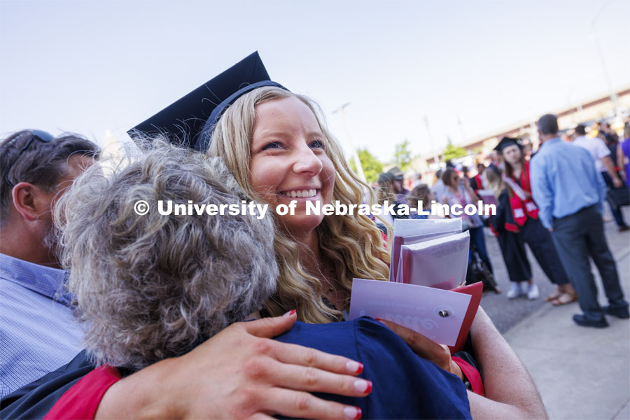 Kaitlyn Lilly is hugged by relatives after the ceremony. Undergraduate Commencement in Memorial Stadium. May 18, 2024. Photo by Craig Chandler / University Communication and Marketing.