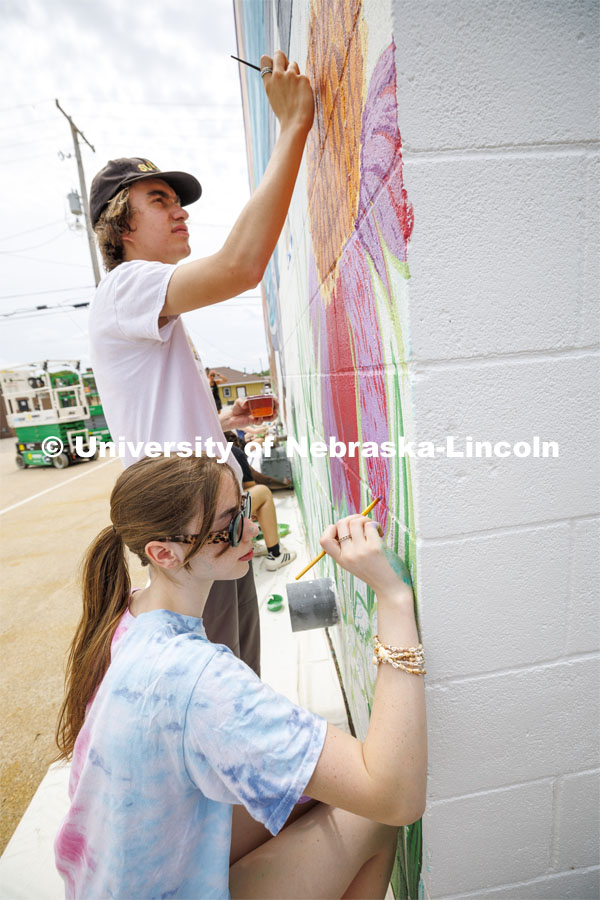 Students paint a coneflower as part of the mural. ARTS 398 - Special Topics in Studio Art III taught by Sandra Williams. The class painted a mural at the Premier Buick, Chevrolet, and GMC dealership in Beatrice. June 3, 2024. Photo by Craig Chandler / University Communication and Marketing.