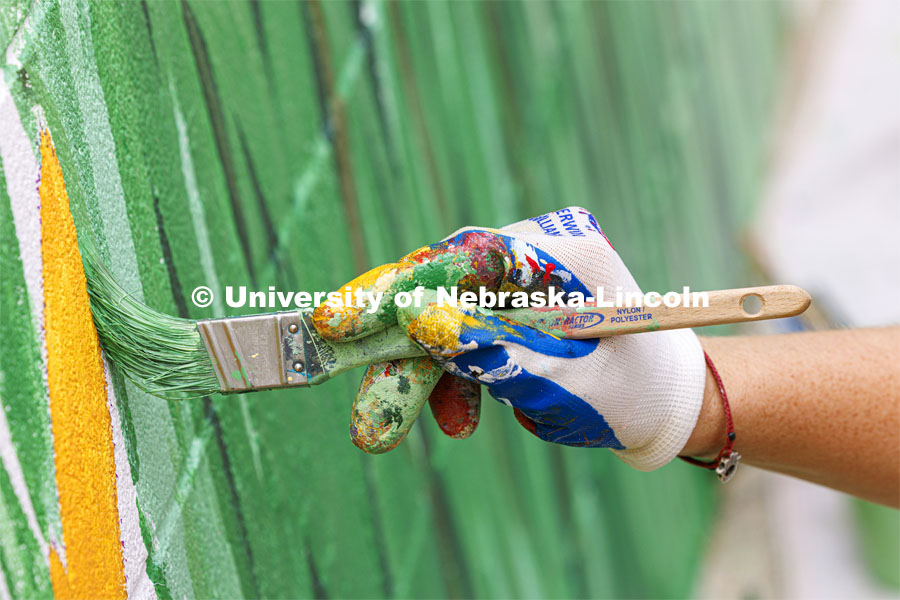 Blades of grass are painted as part of the mural. ARTS 398 - Special Topics in Studio Art III taught by Sandra Williams. The class painted a mural at the Premier Buick, Chevrolet, and GMC dealership in Beatrice. June 3, 2024. Photo by Craig Chandler / University Communication and Marketing.