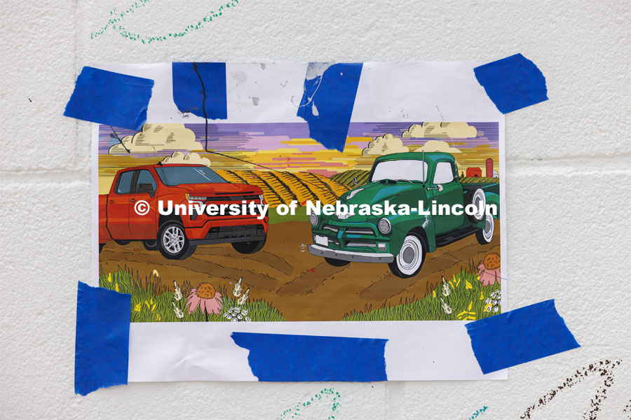 A printout of what the mural is supposed to look like it taped to the wall for reference. ARTS 398 - Special Topics in Studio Art III taught by Sandra Williams. The class painted a mural at the Premier Buick, Chevrolet, and GMC dealership in Beatrice. June 3, 2024. Photo by Craig Chandler / University Communication and Marketing.