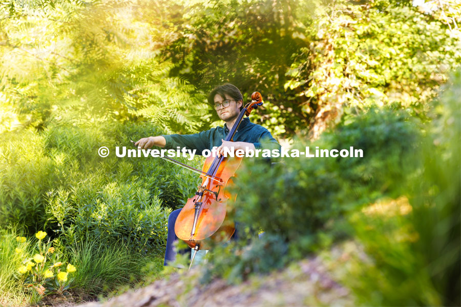 Connor Peterson, a senior in music, plays his cello in the greenspace between Love Library and Hamilton Hall while being filmed for a student spotlight by the Glenn Korff School of Music. June 5, 2024. Photo by Craig Chandler / University Communication and Marketing.