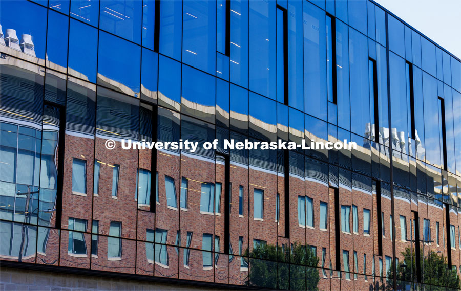 Jorgensen Hall is reflected in the glass walls of Scott Engineering Center. June 11, 2024. Photo by Craig Chandler / University Communication and Marketing.