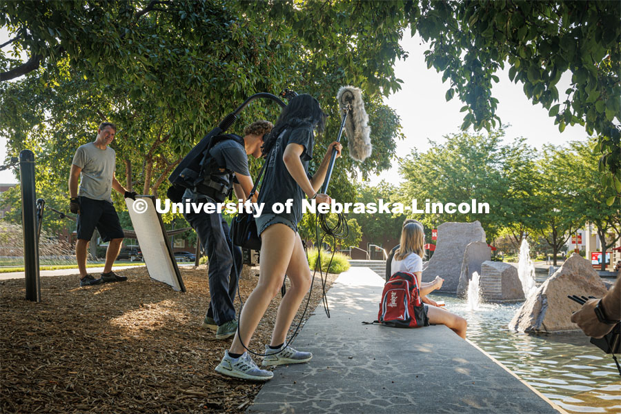 A film crew records students relaxing by Broyhill Fountain. On campus filming. Behind the scenes photo for the university's new "Home Again" national advertisement. June 25, 2024. Photo by Kristen Labadie / University Communication.   