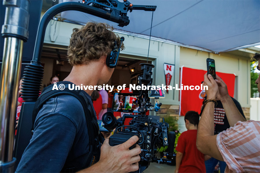 A film crew records a garage husker watch party in Omaha. Behind the scenes photo for the university's new "Home Again" national advertisement. June 26, 2024. Photo by Kristen Labadie / University Communication.   