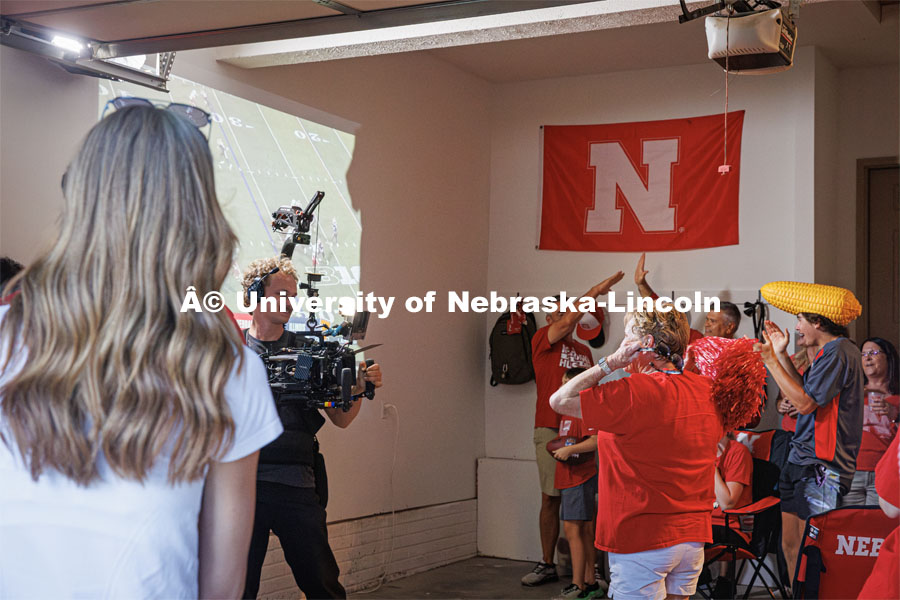 A film crew records a garage husker watch party in Omaha. Behind the scenes photo for the university's new "Home Again" national advertisement. June 26, 2024. Photo by Kristen Labadie / University Communication.   