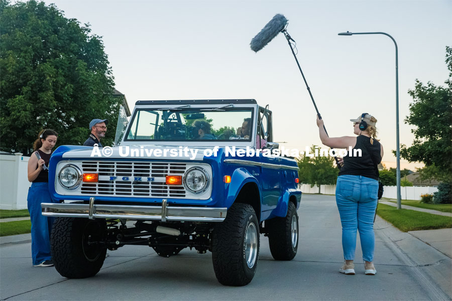 A film crew records a garage husker watch party in Omaha. Behind the scenes photo for the university's new "Home Again" national advertisement. June 26, 2024. Photo by Kristen Labadie / University Communication.   