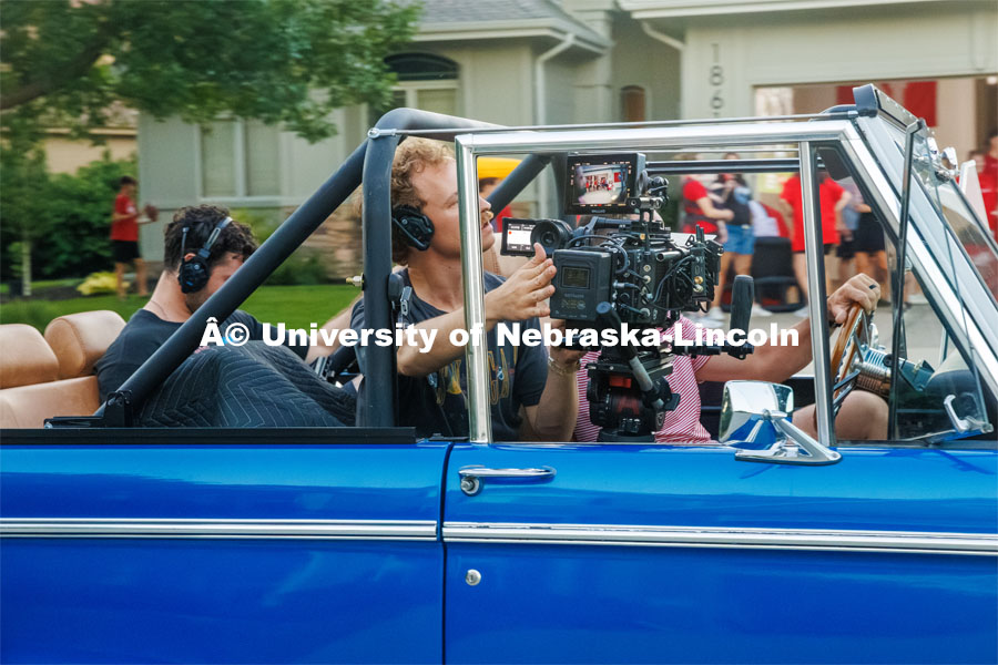 A film crew records a garage husker watch party in Omaha. Behind the scenes photo for the university's new "Home Again" national advertisement. June 26, 2024. Photo by Kristen Labadie / University Communication.   