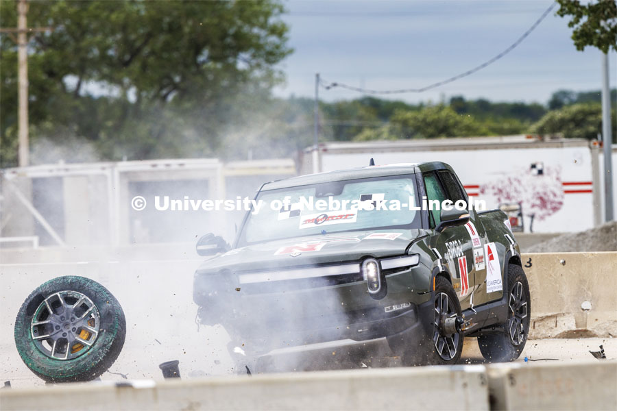 The Rivian R1T electric pickup spins out after striking the barrier. The green paint on the torn-away wheel is used to mark where it struck the barrier. The pickup crashed into a concrete barrier but did not go through it. In research sponsored by the U.S. Army Engineer Research and Development Center, the University of Nebraska-Lincoln’s Midwest Roadside Safety Facility is investigating the safety questions raised by the burgeoning number of electric vehicles on the nation’s roadways by performing crash test performed on a guardrail at 62 mph, the 7,000-plus-pound, Rivian R1T truck crashed into a temporary barrier. The barrier deflected several feet but the truck did not go through the barrier. July 1, 2024. Photo by Craig Chandler / University Communication and Marketing.