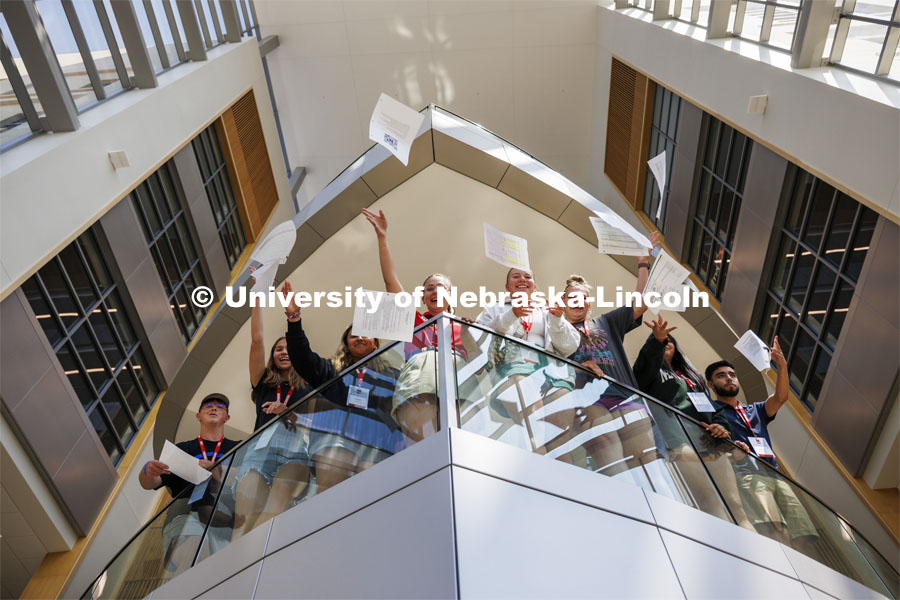 For the final day of this year’s New Student Enrollment, each student group’s fun-photo contest was to illustrate the theme “Last Day of School”. Ana Wombacher’s group flung Ana’s orientation leader papers from the balcony in the College of Business. Final day of 2024 New Student Enrollment. July 11, 2024. Photo by Craig Chandler / University Communication and Marketing.