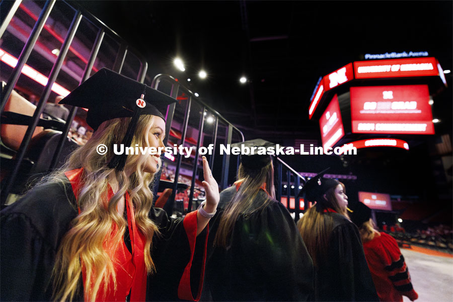 Sheradyn Johnson waves to family and friends as she waits to enter the arena for commencement. Summer Commencement ceremony in Pinnacle Bank Arena. August 17, 2024. Photo by Craig Chandler / University Communication and Marketing.