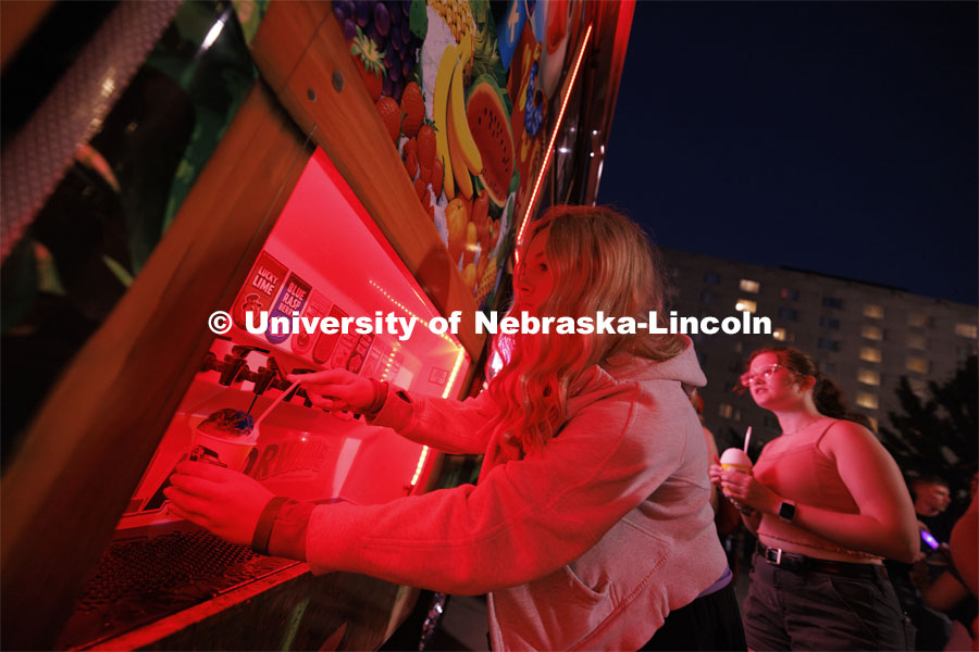 Eliana Vondracek of Dakota Dunes, South Dakota adds syrup to her Kona Ice at the block party. Block Party at Harper Schramm Smith residence halls. August 19, 2024. Photo by Craig Chandler / University Communication and Marketing.