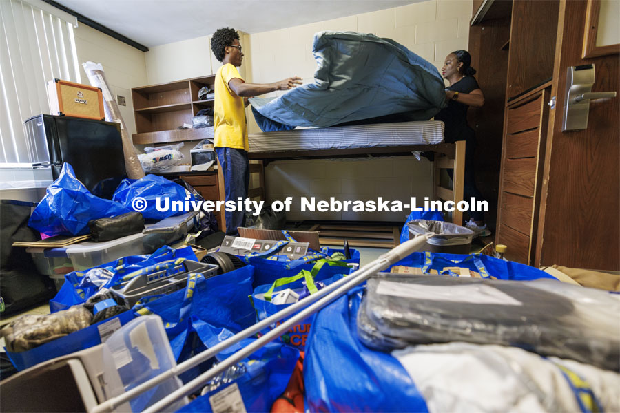 Isaiah Vasser and his mom, Shardea Gallion. make his bed in Smith Hall. The two are from St. Louis and Shardea is a 2008 UNL graduate in broadcasting. Harper Schramm Smith move-in. August 18, 2024. Photo by Craig Chandler / University Communication and Marketing.