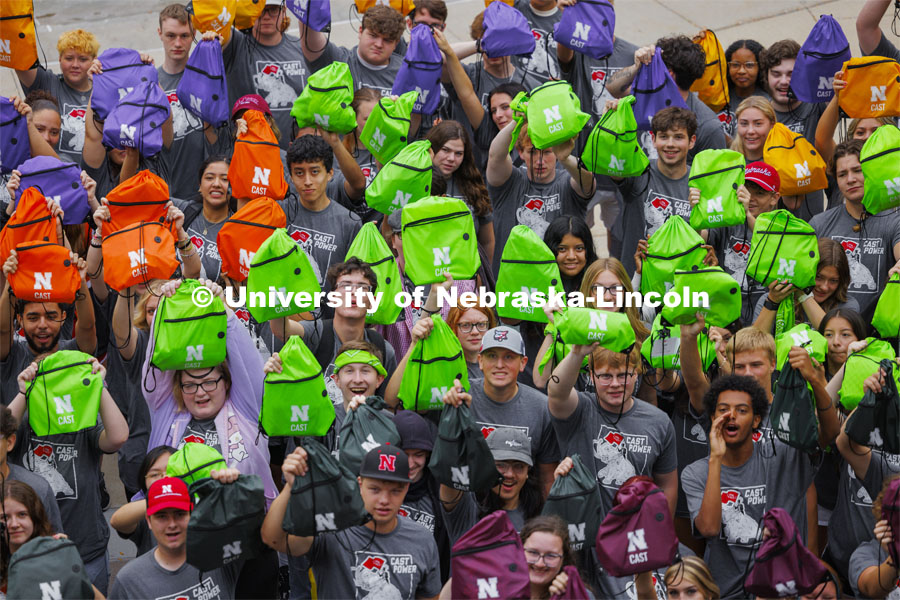 Students hold up their colored backpacks. 300 Center for Academic Success and Transition (CAST) first-year students and 48 mentors pose for a group photo at the end of their four-day camp. August 22, 2024. Photo by Craig Chandler / University Communication and Marketing.