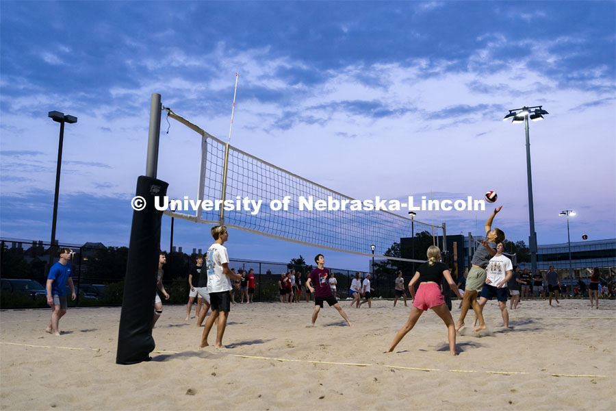 Freshman Shane Rothenberger (second from right) leaps into the air to hit the volleyball during the Suites-Courtyards Block Party event. Big Red Welcome events. August 22, 2024. Photo by Jordan Opp for University Communication.