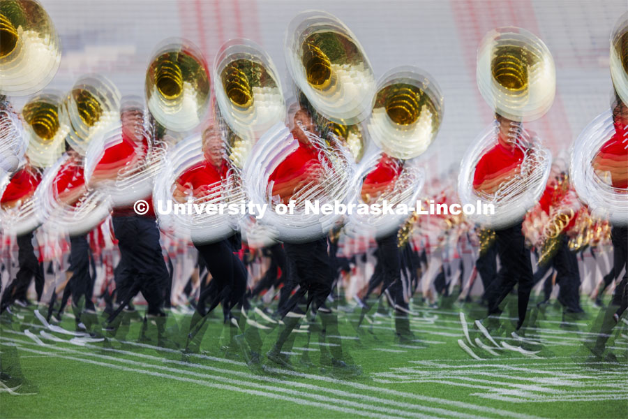 Blurred image of the sousaphones marching at the Cornhusker Marching Band exhibition in Memorial Stadium. August 23, 2024. Photo by Craig Chandler / University Communication and Marketing.