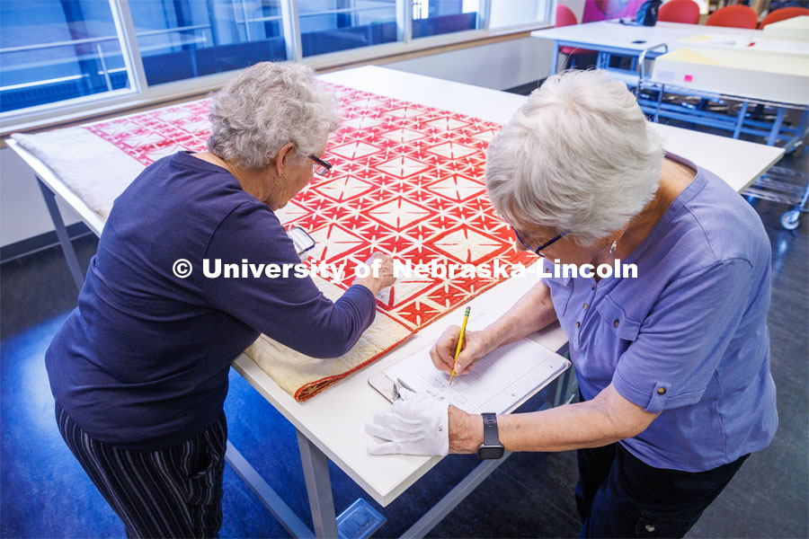 Volunteers Carolyn Kitterer (left) reads the names off the quilt while Susan Macy writes them down. International Quilt Study Center and Museum Genealogical Task Force. August 29, 2024. Photo by Kristen Labadie / University Communication.